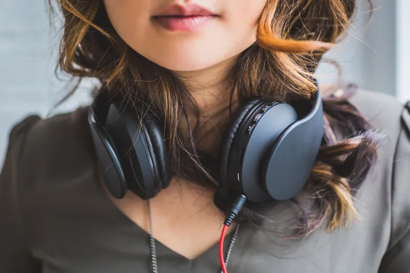 Close-up of a woman with headphones around her neck, face partly out of frame